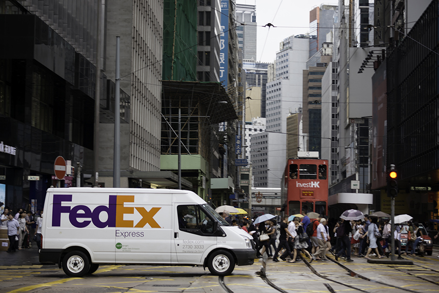 FedEx delivery van drives across busy Hong Kong street