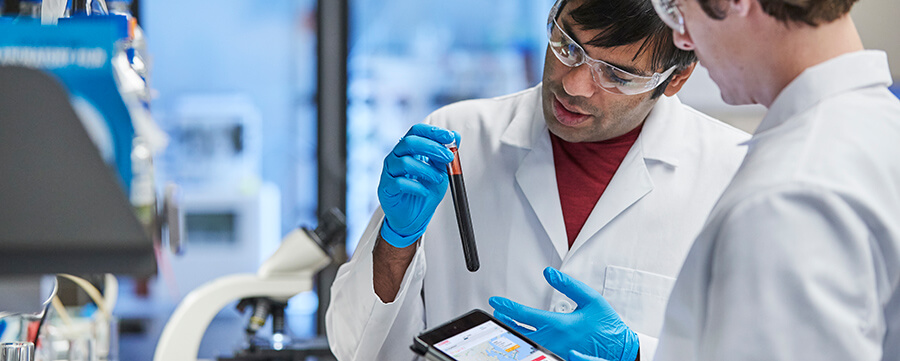 Male scientists examine a beaker sample