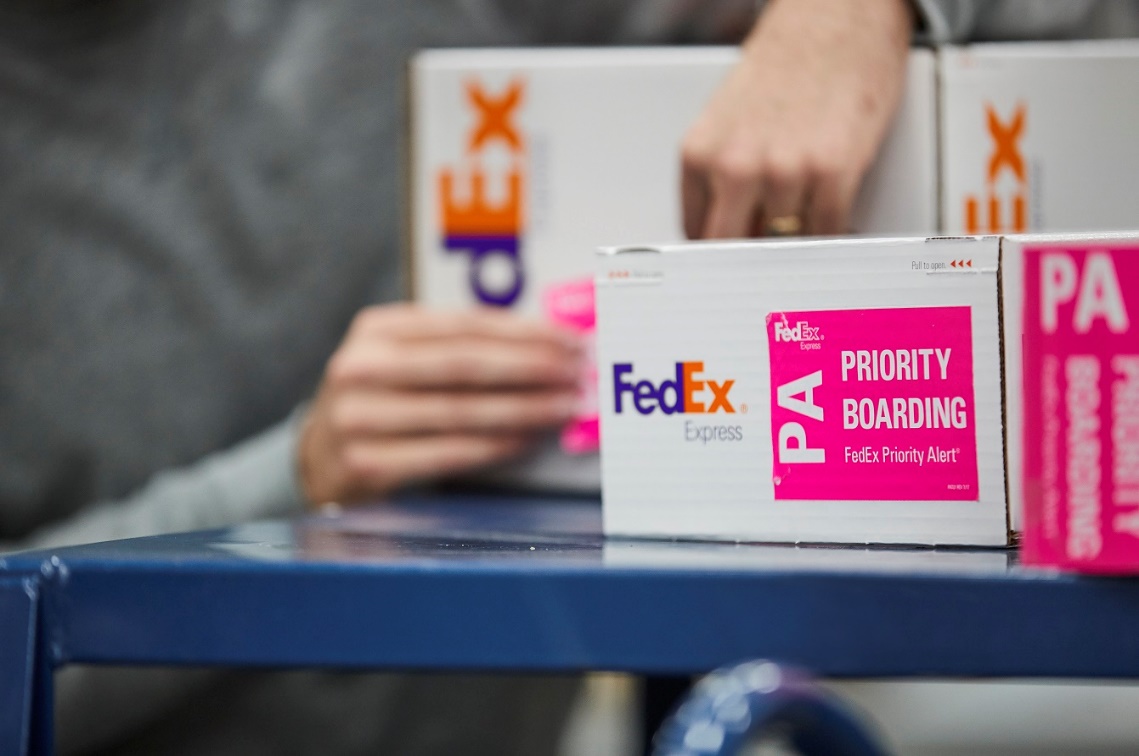 White FedEx package with priority boarding sticker on it
