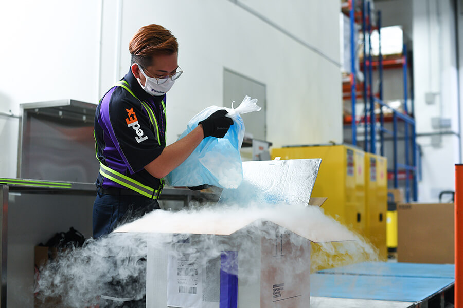 Male FedEx employee handles a cold shipping package