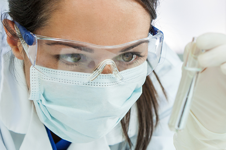 Female pharmacist checking test tube in lab