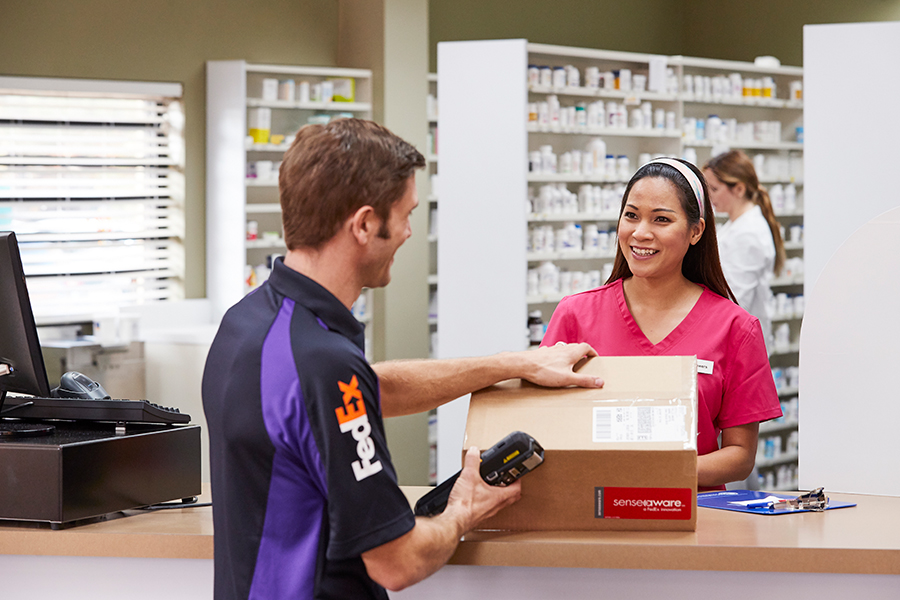 Female pharma worker packing FedEx box
