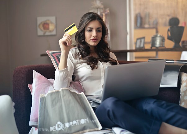 A woman shopping online with laptop and holding credit card