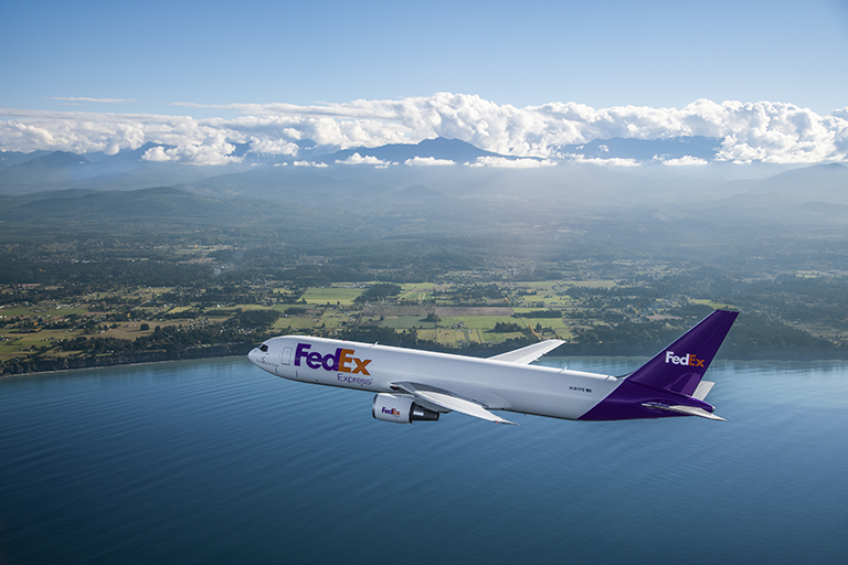 FedEx employee scans a package in a handbag store