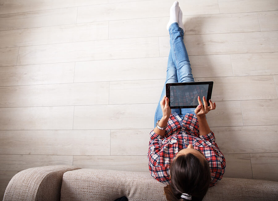 Female on sofa browsing on tablet