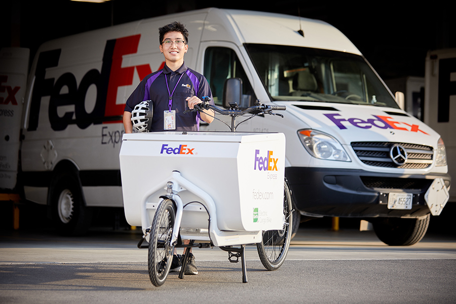 Asian FedEx delivery driver with electric delivery bike
