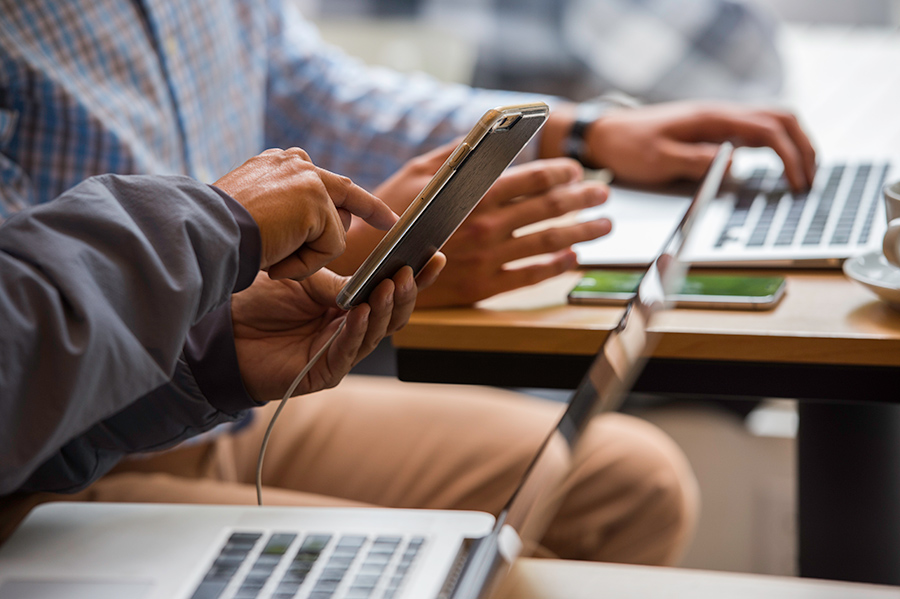 Men using mobile phones and laptop computers