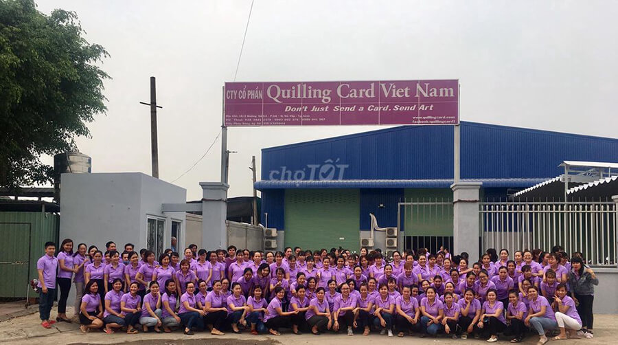 Vietnamese factory workers in purple uniform outside workshop