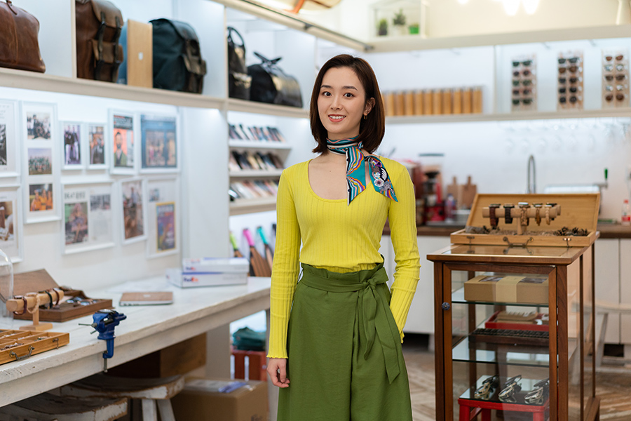 Asian woman wearing a scarf stands in a store
