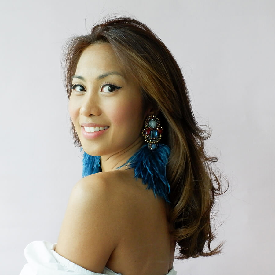 Filipina female with long hair wearing blue feather earrings