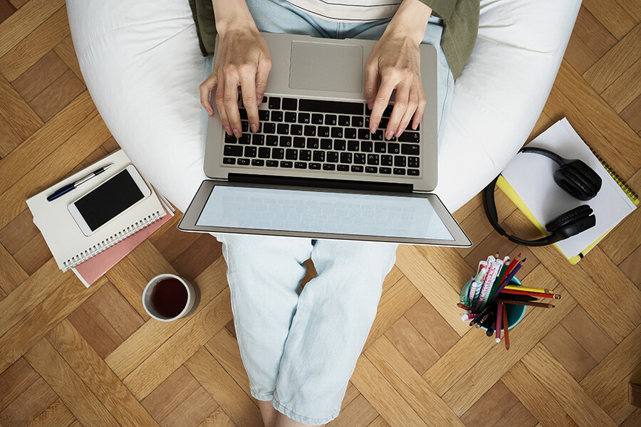 Remote worker on sofa with laptop and stationery