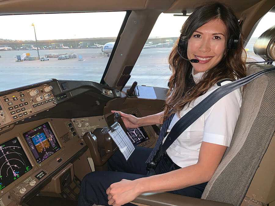 Female pilot in cockpit smiles