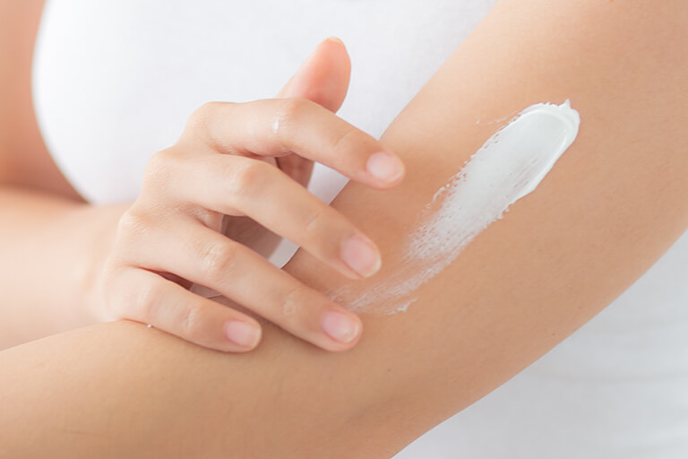 Hand applying body cream