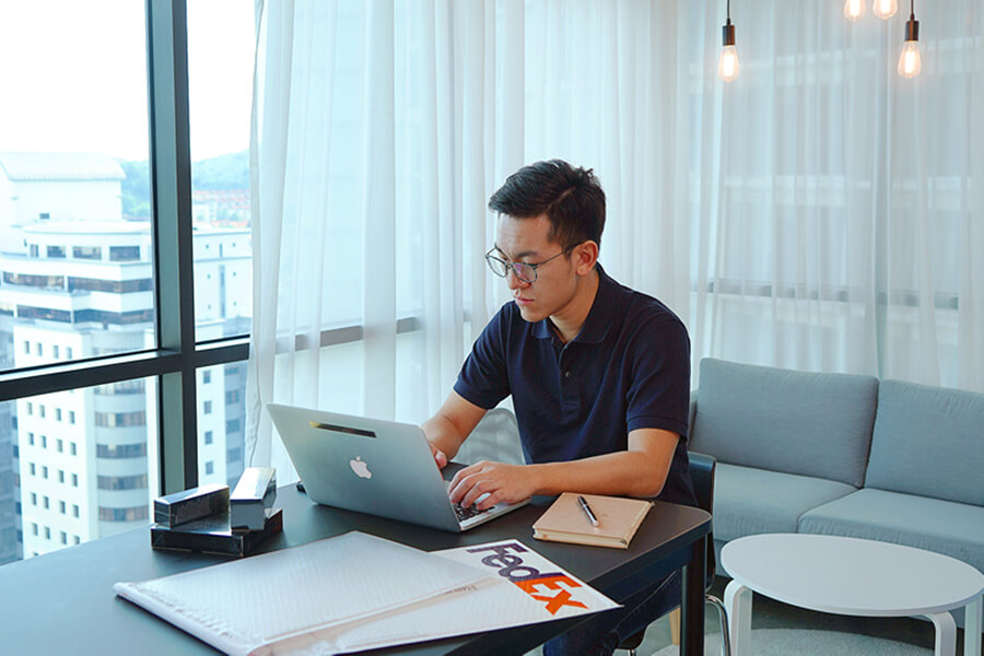 man working at a desk with FedEx package