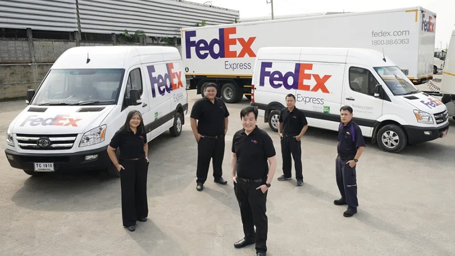 Uniformed FedEx couriers and delivery vans