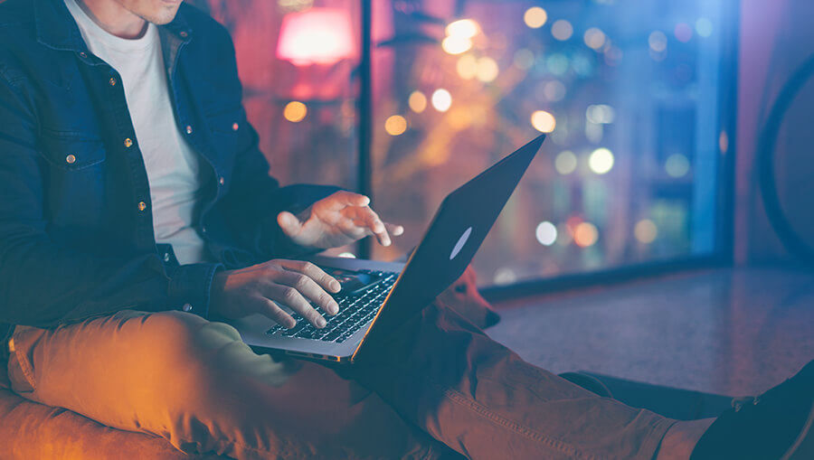 Young man sitting on the floor with laptop