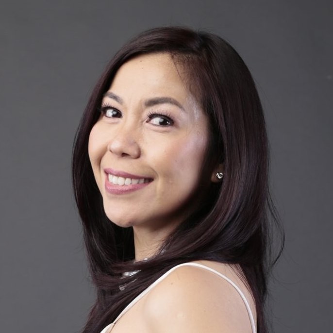 Headshot of smiling Filipina in white strappy top