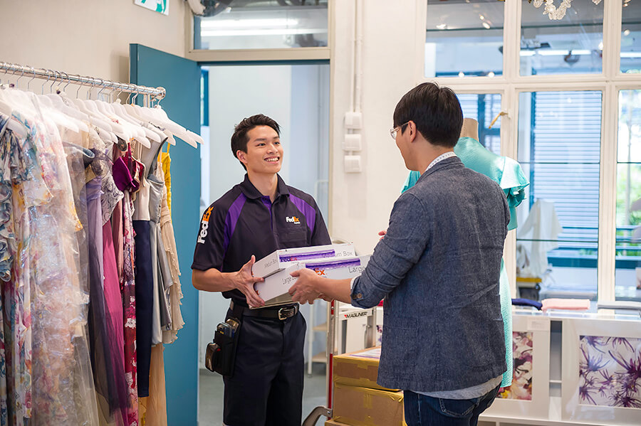 FedEx courier picks up FedEx boxes from dress shop