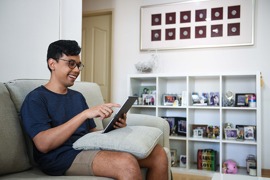 A boy shopping online happily with tablet