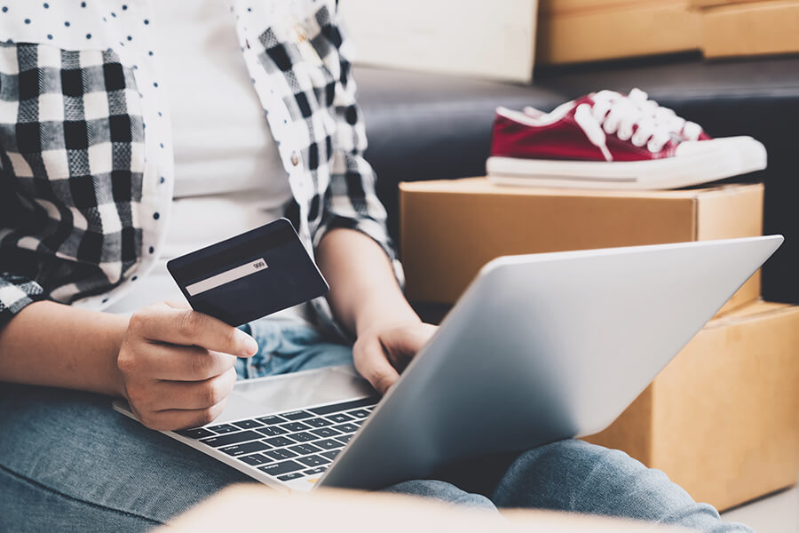 Man holding credit card to do online payment while using laptop