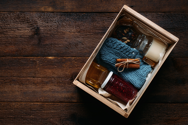 Gift box with candle, jam socks and cinnamon stick