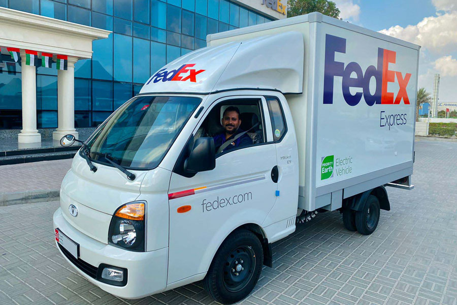 Middle-Eastern-male-courier-in-driver-seat-of-FedEx-truck-outside-depot