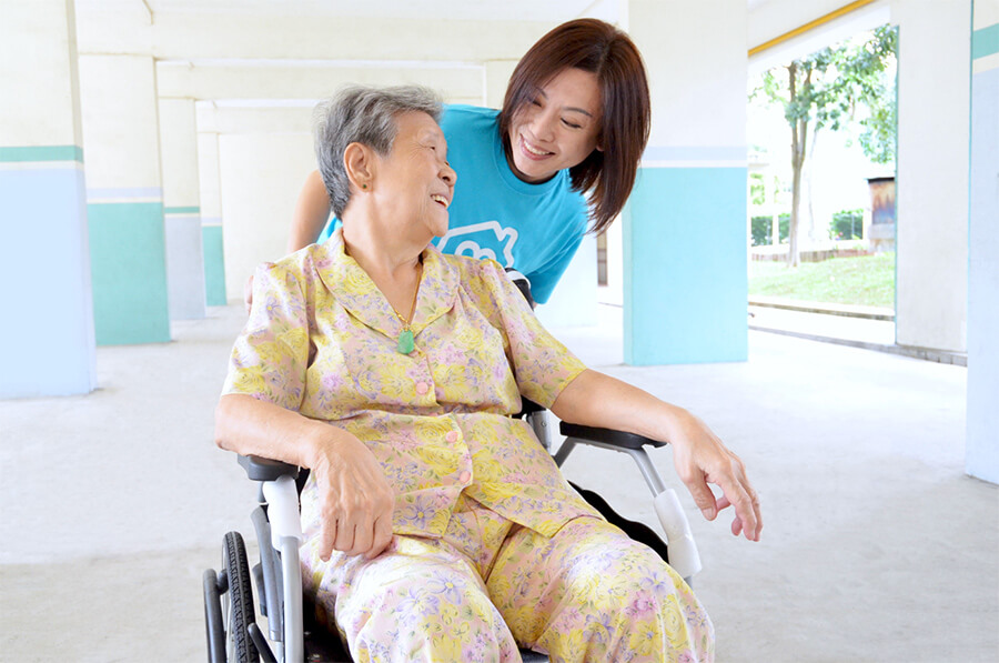 Female interacting with an elderly woman in wheelchair
