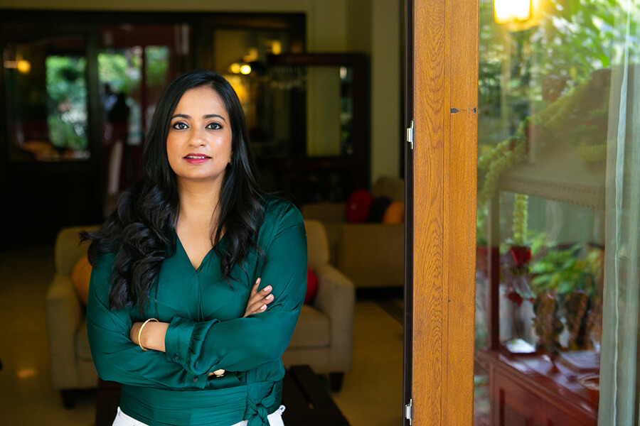 Indian female in green silk shirt stands in doorway