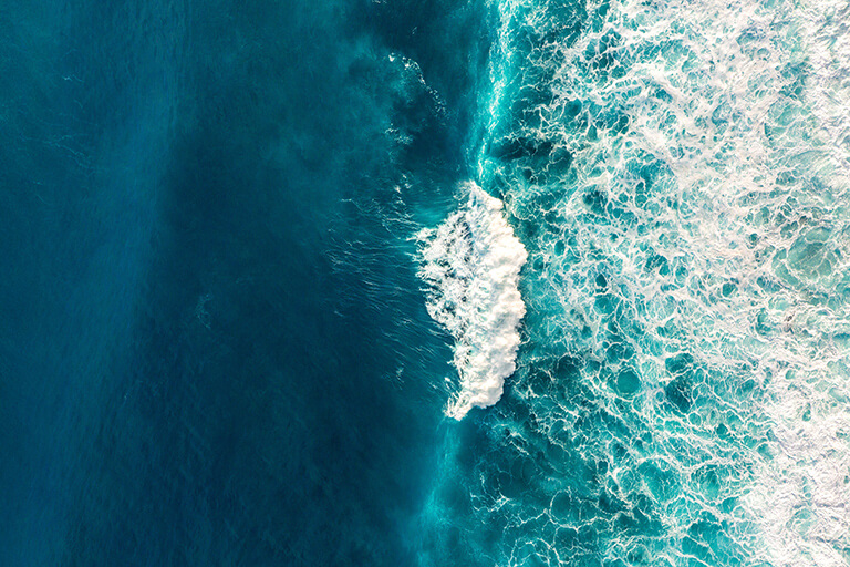 Turquoise blue sea and rolling foamy wave