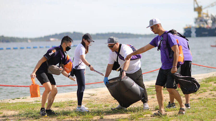 5 FedEx volunteers and couriers pick up trash on shoreline