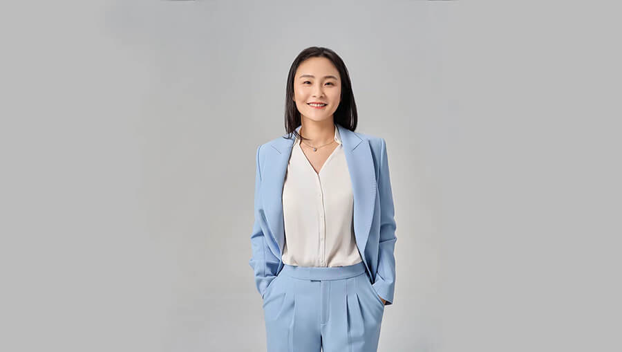 A Chinese woman wearing suit and standing