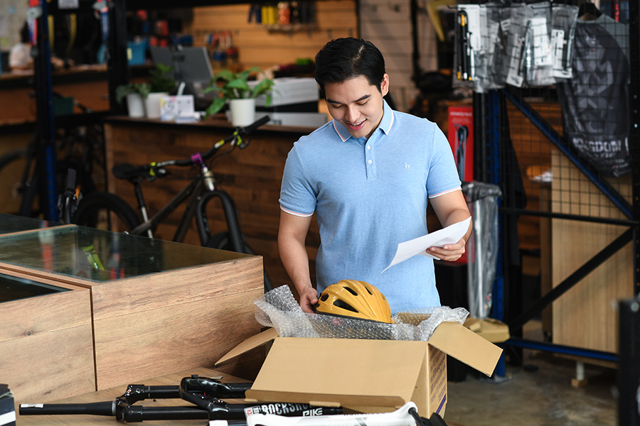 Male SME unpacks bike helmet in bike shop