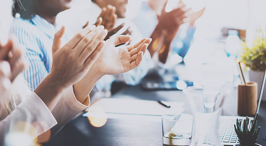 Employees clapping hands in meeting
