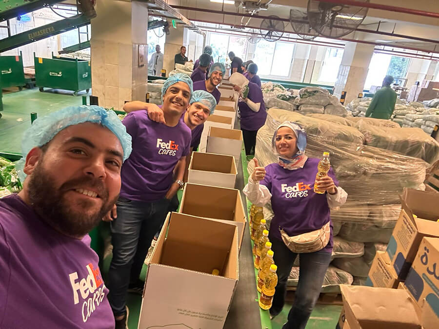 A group of FedEx employees packing food items to help the community