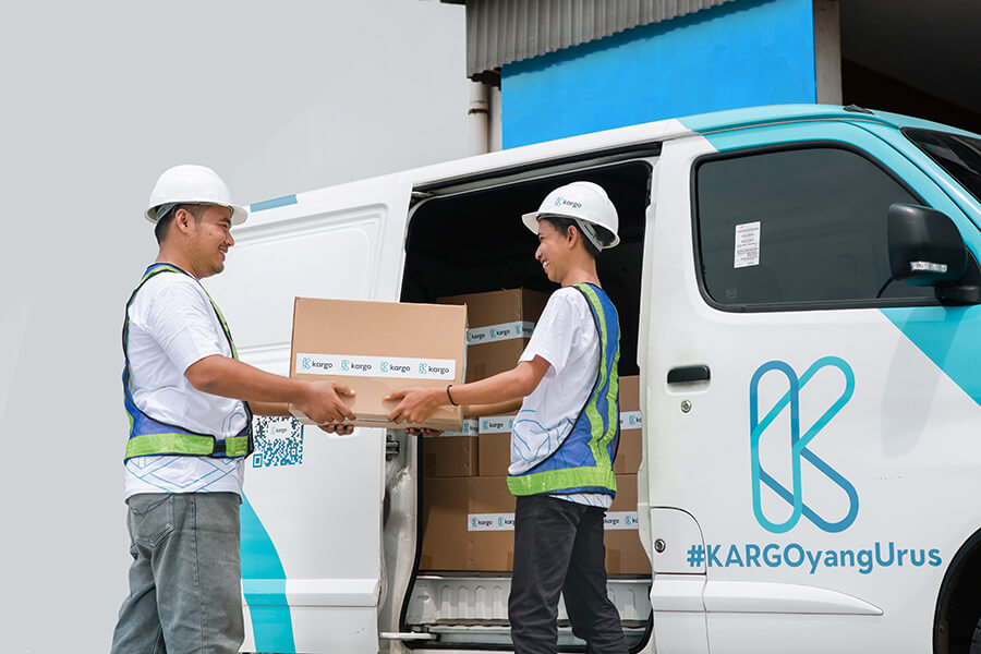 Two workers loading boxes to a van