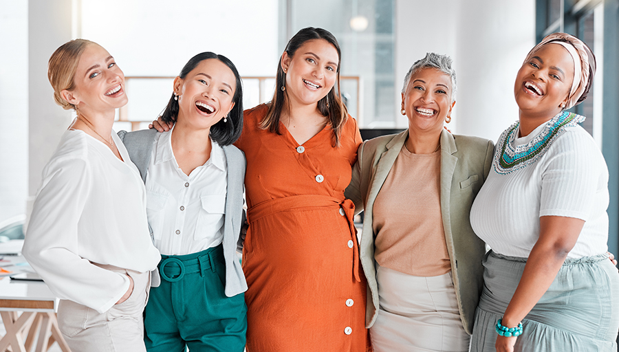 Diverse group of professional women in the office hugging