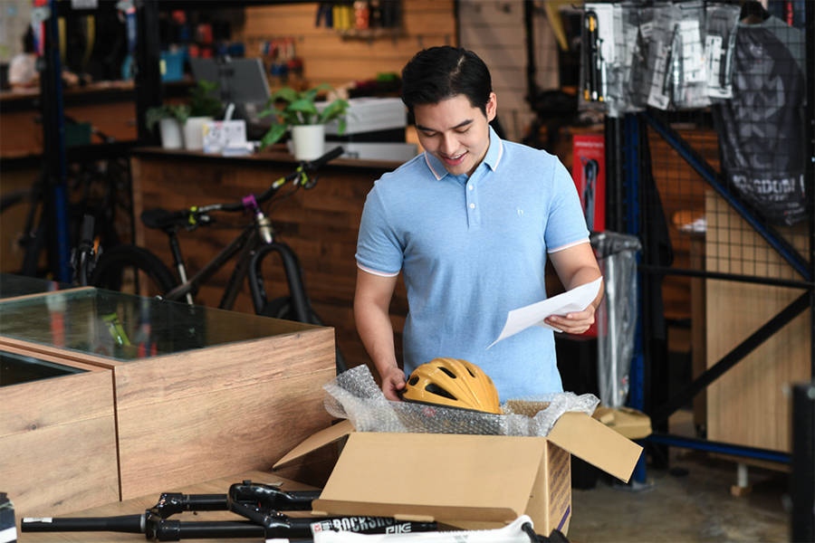 Smiling customer opening parcel with product inside