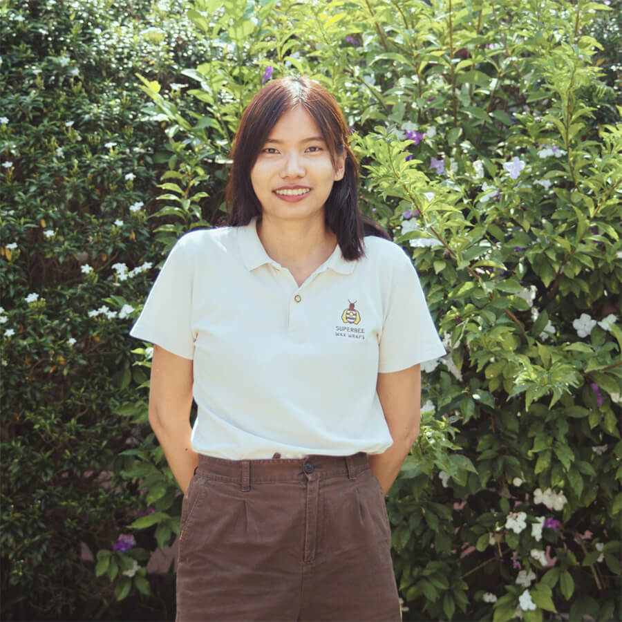 Woman in uniform standing in front of a bush