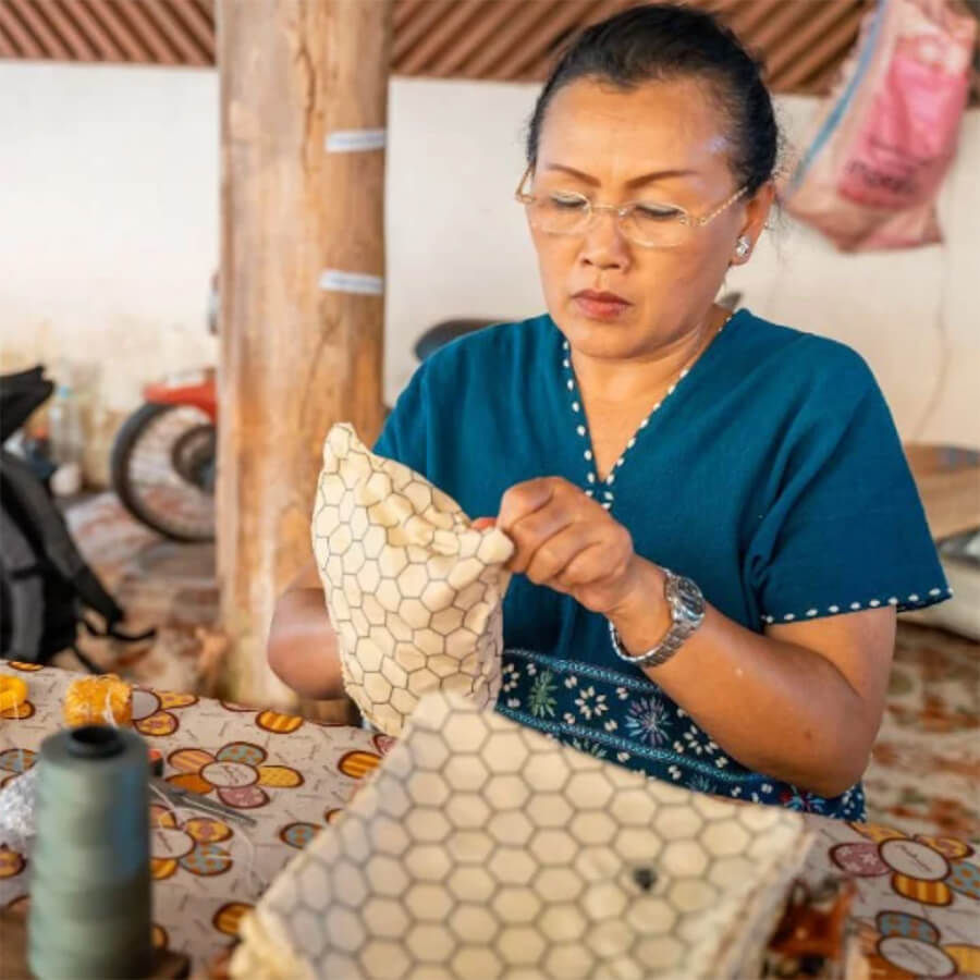Woman making a reusable beeswax wrap by hand