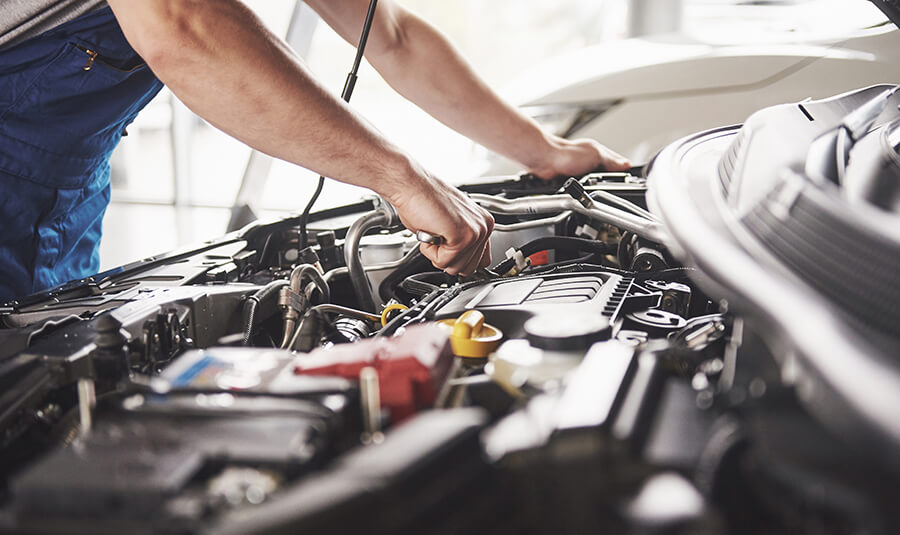 A mechanic fixes a car engine