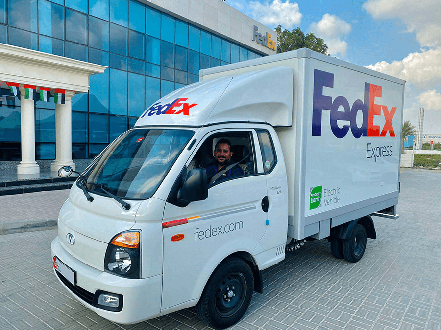 A FedEx electric vehicle is parked in front of a building