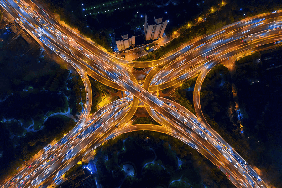 Aerial view of highway junctions shape letter x cross at night.