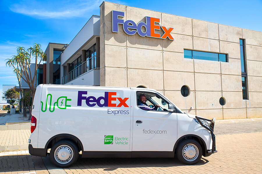 A FedEx electric vehicle is parked in front of a building