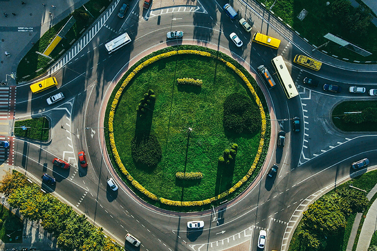 Aerial view of grass turf traffic roundabout with moving traffic