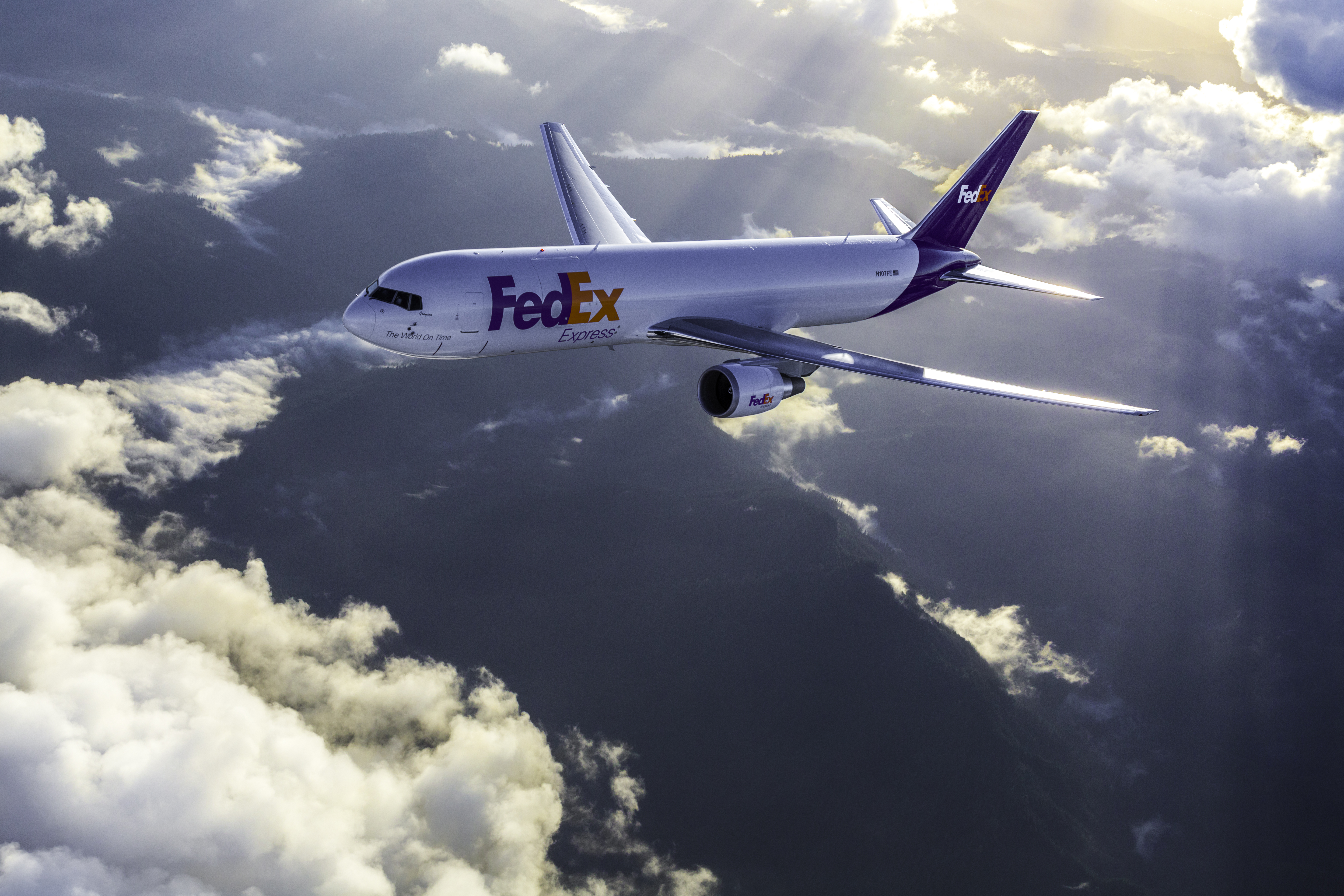 FedEx airplane flying above clouds