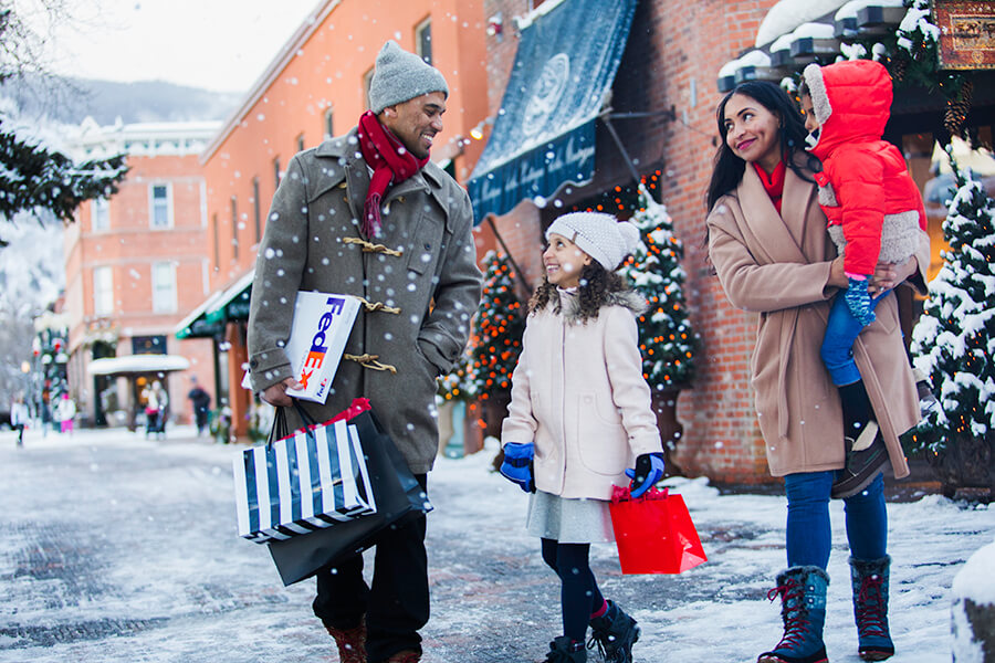 Family of four doing Christmas shopping in the snow
