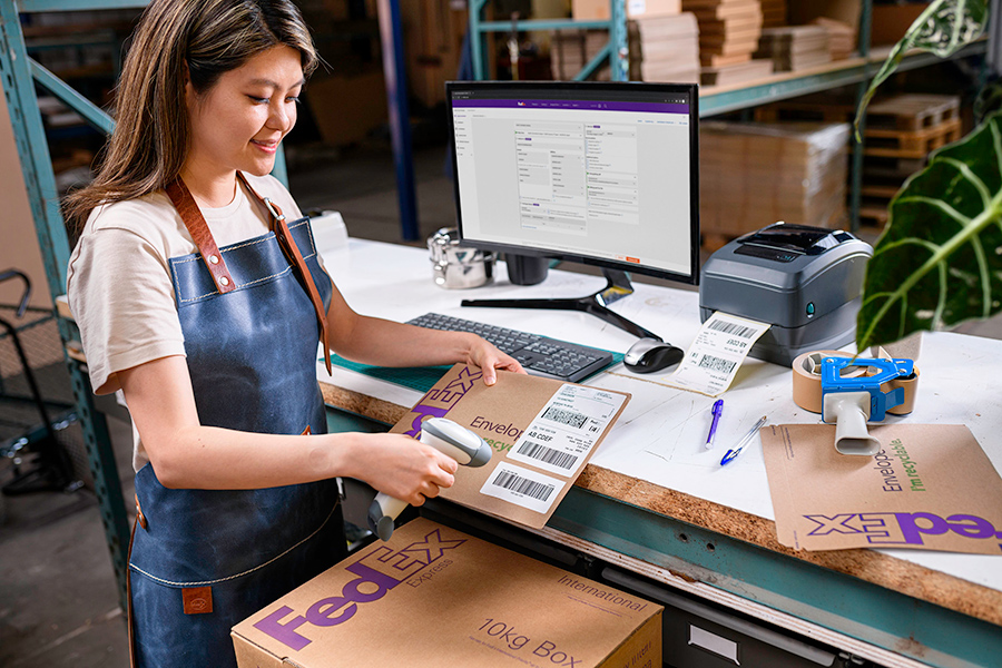 Asian female SME scans FedEx box and prints labels