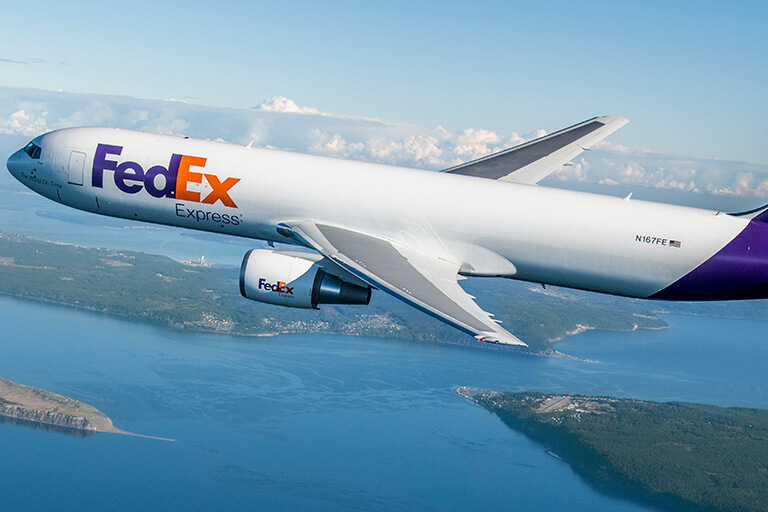 FedEx branded plane flies in the sky
