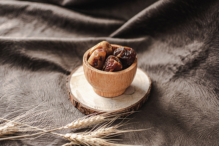 Some Medjool dates placing on a wooden bowl