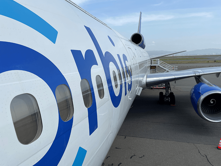 Plane with blue Orbis logo on tarmac in airport